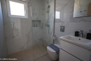 a bathroom with a shower and a toilet and a sink at Rodos Suites on the Park in Rhodes Town +10 photos
