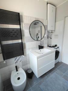 a bathroom with a sink and a toilet and a mirror at Petit Brunò in Monfalcone
