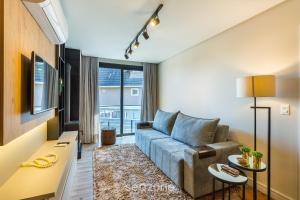 Apto Encantador c/ lareira em Gramado STA0305 في غرامادو: غرفة معيشة بها أريكة وطاولة