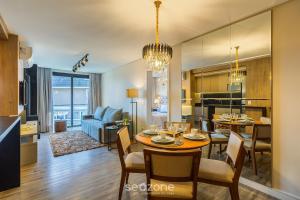 Apto Encantador c/ lareira em Gramado STA0305 في غرامادو: مطبخ وغرفة معيشة مع طاولة وكراسي