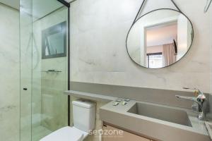 Apto Encantador c/ lareira em Gramado STA0305 في غرامادو: حمام مزود بحوض ومِرآة +20 صورة