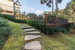 Apto Encantador c/ lareira em Gramado STA0305 في غرامادو: مسار حجري في ساحة بها سياج