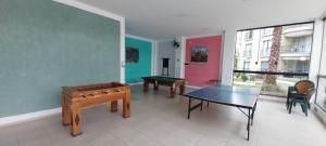 a room with two tables and a ping pong table at Flat Quartier - Aldeia das Águas in Barra do Piraí