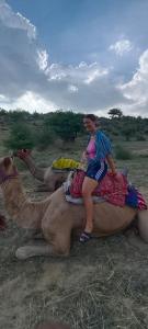 a woman riding on the back of a camel at Hostel The Travellers Heaven in Jaisalmer