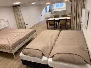 two beds in a room with a kitchen and a table at Herengracht 204 Souterrain Studio Apt without kitchen in Amsterdam