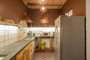 a kitchen with a refrigerator and a counter top at Maison Depla with rooftop, Jacuzzi, pool, and BBQ in Buenos Aires