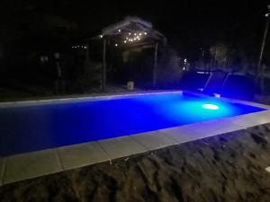 ein blauer Pool in der Nacht mit Lichtern in der Unterkunft Montañas Del Sol in Santa Rosa de Calamuchita