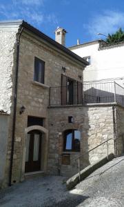 Casa de piedra antigua con balcón en una calle en Residenza Sant'Antonio en Deliceto