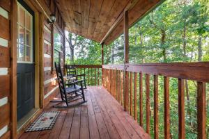 a porch of a cabin with two chairs on it at Views, King & Sofa Bed, Hot Tub, Firepit And Deck in Sevierville