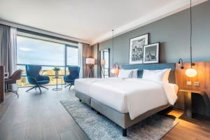 a hotel room with a large bed and a desk at ScanHotels City in Rostock