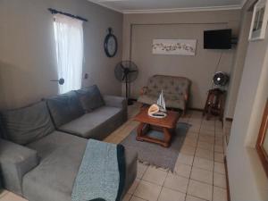 a living room with a couch and a table at Puravida guesthouse in Umkomaas