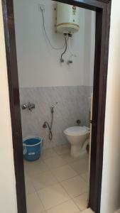 a bathroom with a toilet and a bucket in it at VB Hotels in Haridwār