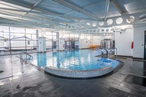 a large swimming pool in a large building at Platinum Caravan with Decking & Garden in Abergele
