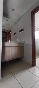 a reception desk in a room with a mirror at Flat Quartier - Aldeia das Águas in Barra do Piraí