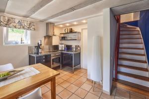 a kitchen with a table and a staircase in a room at Molls Ferienhäusel in Sankt Martin