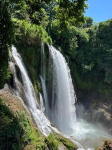 a waterfall in the middle of a forest at Hotel Ruby in Agua Blanca Sur