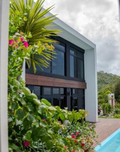 a house with black windows next to a swimming pool at Villa Odyssea BVI in Tortola Island