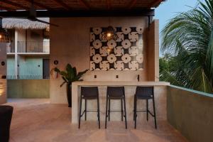 a bar on the side of a house with two stools at Casa Nadó in Brisas de Zicatela