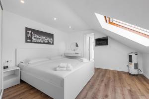 a white bedroom with a white bed and a staircase at Meta Hotel in Cologne