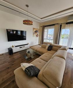 a living room with a couch and a flat screen tv at Modern and bright light room 