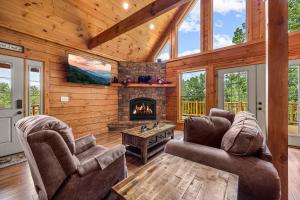a living room with a fireplace in a log cabin at Whataview And Privacy Too by American Patriot Getaways in East Fork