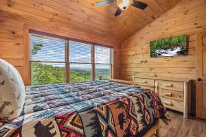 a bedroom with a bed in a log cabin at Whataview And Privacy Too by American Patriot Getaways in East Fork