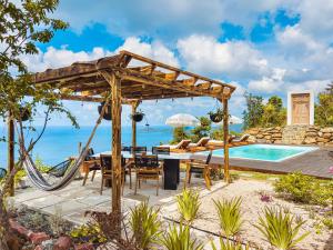 a patio with a hammock and a swimming pool at Villa Odyssea BVI in Tortola Island