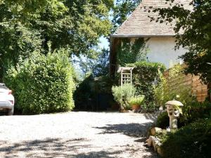 a garden with a house with a gate and a yard at Le Gîte du Chêne Rouvre in Corbeil-Cerf
