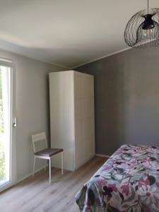 a bedroom with a bed and a chair and a cabinet at Petit Brunò in Monfalcone +12 photos