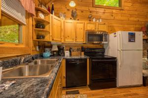 a kitchen with a sink and a refrigerator at Wild At Heart Wears Valley by American Patriot Getaways in Hatchertown +12 photos