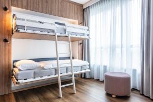 a bedroom with two bunk beds and a stool at ScanHotels City in Rostock