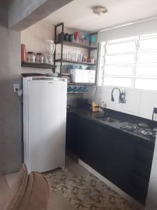 a kitchen with a white refrigerator and a sink at Studio à Beira-mar - Santos in Santos +5 photos