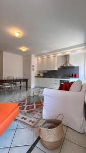 a living room with a white couch and a kitchen at La Margherita in Salò