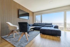 a living room with a couch and a chair at Airport Prague Luxury Apartment & Spa in Prague