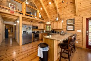 eine Küche mit einer Mittelinsel in einem Blockhaus in der Unterkunft Wildflowers by American Patriot Getaways in Cartertown