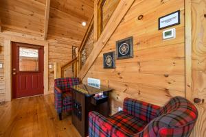 eine Blockhütte mit 2 Stühlen und einer Bar in der Unterkunft Wildflowers by American Patriot Getaways in Cartertown