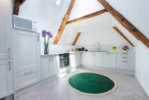 Una cocina con gabinetes blancos y una alfombra verde en el piso. en Barbican's Luxurious Townhouse, en Plymouth