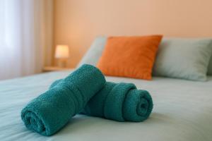 a towel animal is laying on a bed at Le Sky - Penthouse d'Exception avec Vue Panoramique et Terrasse en Plein Cœur d'Orsay Paris-Saclay in Orsay