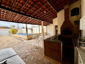 a kitchen with a brick fireplace and a patio at Casa Vitória in Aparecida