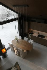 a dining room with a table and a large window at Black Villa, Aurora View Bath & Sauna, Private Design Villa in Lapland in Kolari