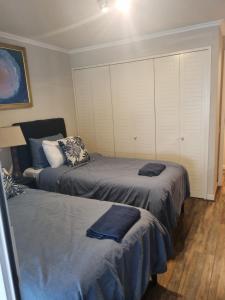 a bedroom with two beds with towels on them at Reñaca Cochoa departamento frente al mar in Vina del Mar
