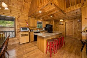 una cucina con una grande isola in una cabina di legno di Wonders In The Sky by American Patriot Getaways a Oldham