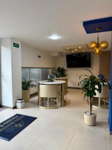 an office lobby with a table and potted plants at Hotel Boutique Paralela Real. in Manizales +27 photos