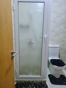 a bathroom with a glass shower door next to a toilet at Maison Mima in Tarrafal +9 photos