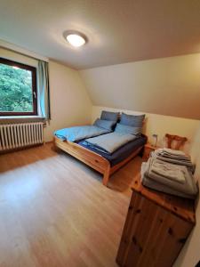 a bedroom with a bed in a room with a window at Ferienwohnung-1-Nei-Stich-19a in Norddorf