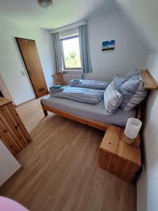 a small bedroom with a bed and a window at Ferienwohnung-1-Nei-Stich-19a in Norddorf