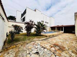 a building with a stone walkway in front of a building at Casa Vitória in Aparecida