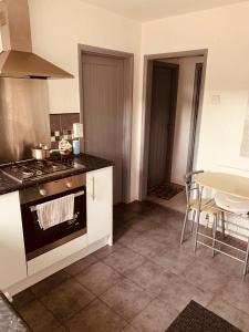 a kitchen with a stove and a table with chairs at The Glenton Getaway in Peterborough
