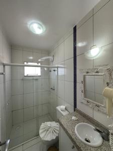 a white bathroom with a sink and a shower at Pousada Brisa do Mar in Bombinhas +73 photos