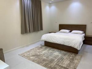 a bedroom with a large bed and a rug at شقق الضباب 1 in Al Baha